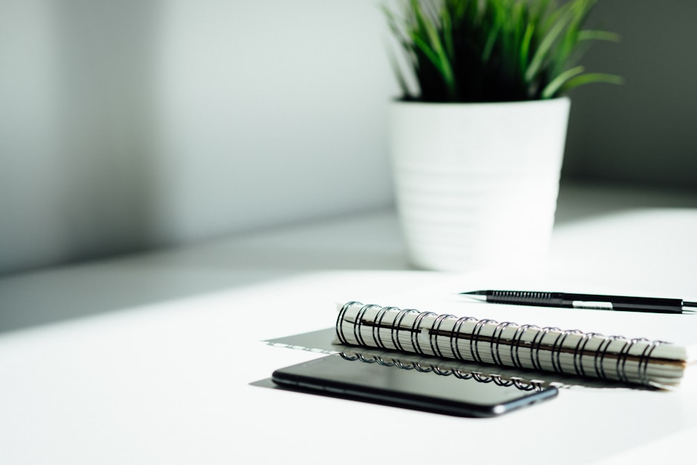caneta, notebook e smartphone na mesa