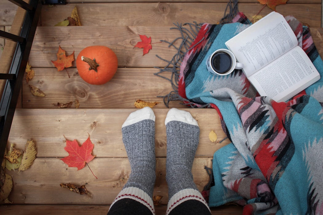 Fall Bucket List Image socks and coffee with pumpkin and leaves and deck in background