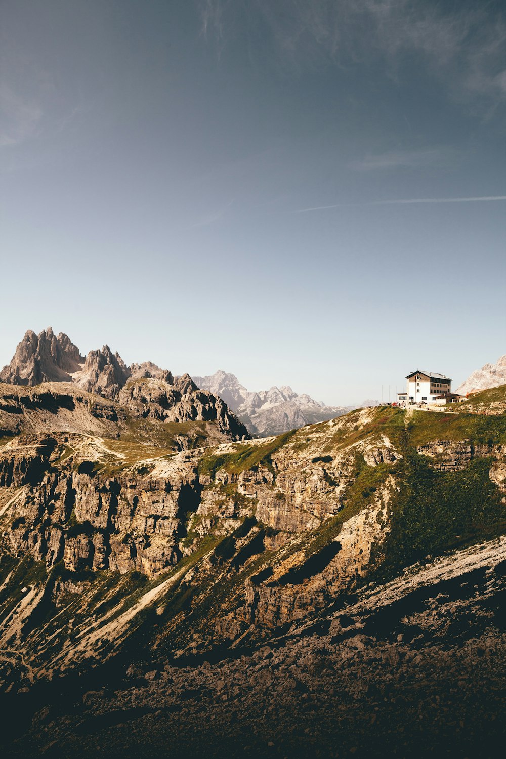 white concrete building surrounded by rocky mountains