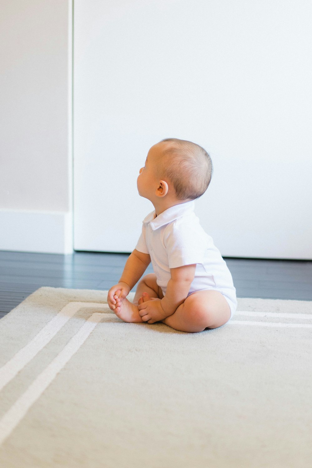 bébé assis sur tapis beige