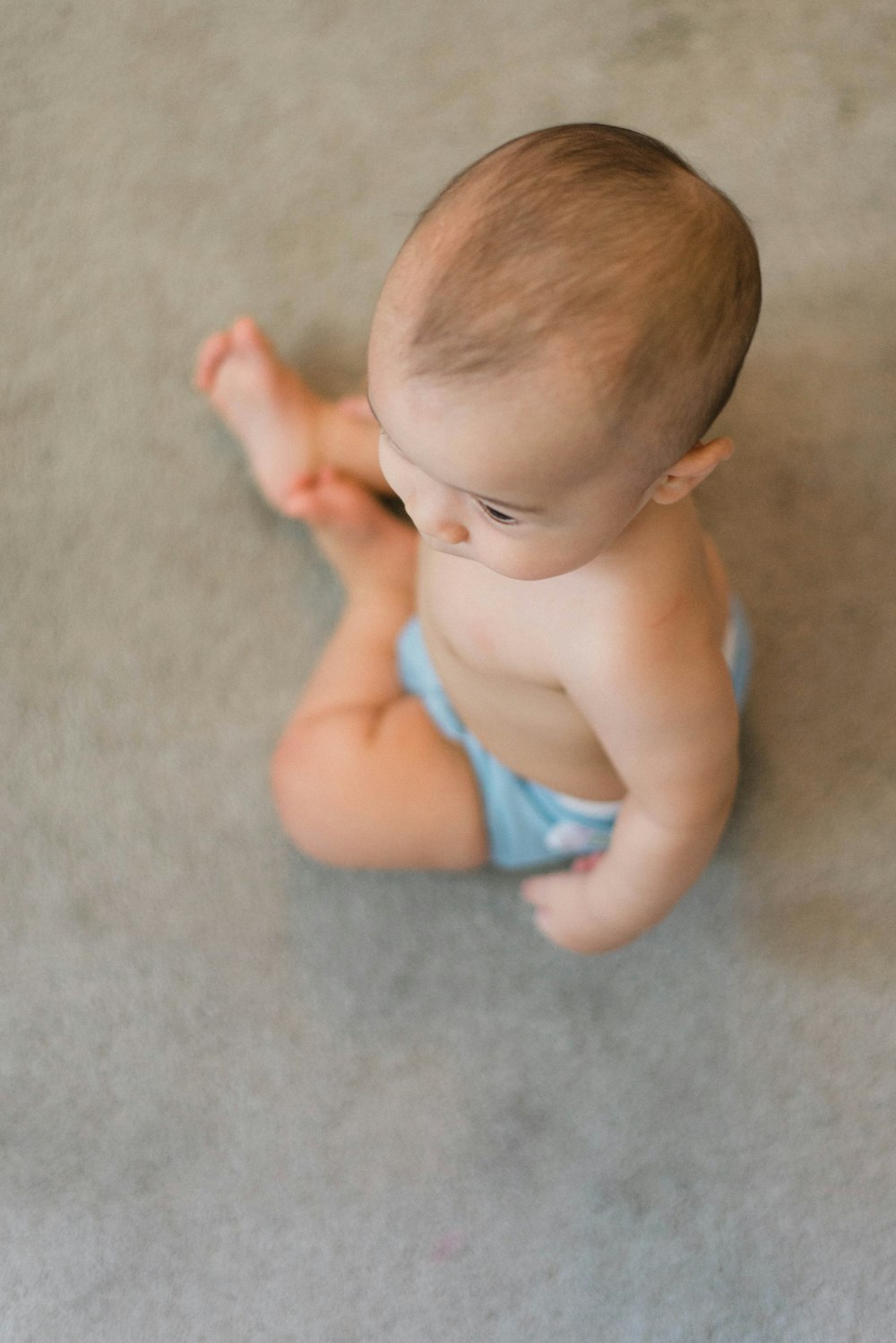 매트에 앉아있는 아기의 선택적 초점 사진