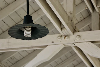Close-up of a rustic wooden pendant light hanging over a farmhouse dining table.