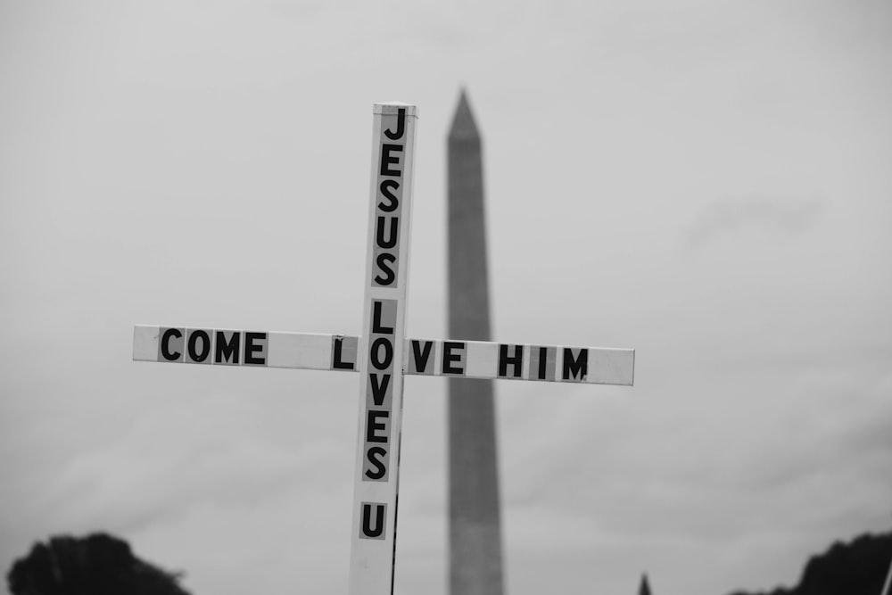 Una foto in bianco e nero di un cartello stradale con il monumento a Washington sullo sfondo