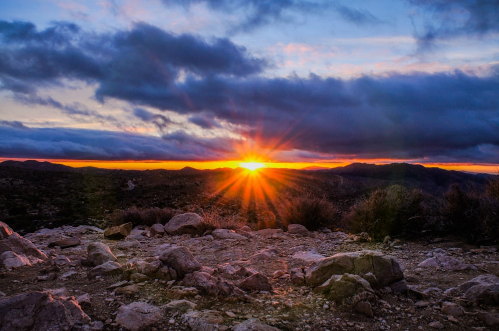 mountain range under cloudy sky during sunset