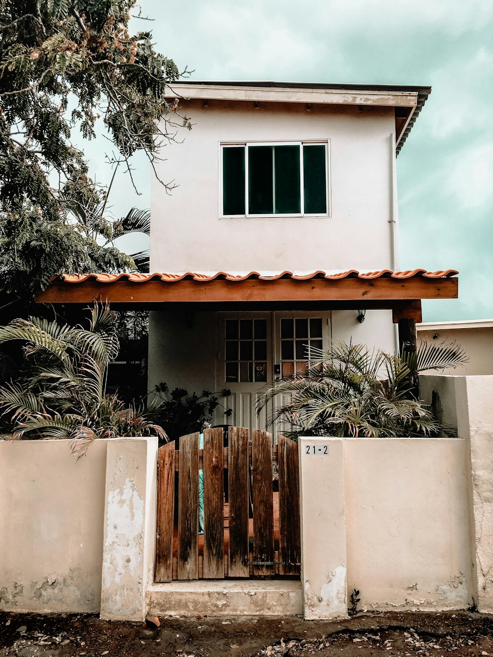 Casa de concreto branco perto da árvore durante o dia