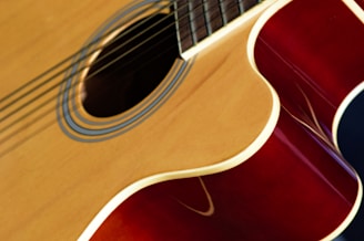 Hands carefully applying finish to an acoustic guitar body.
