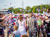 newly wed couple surrounded by people throwing confetti