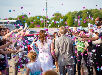 newly wed couple surrounded by people throwing confetti