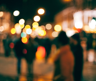 a blurry photo of people walking down a street at night