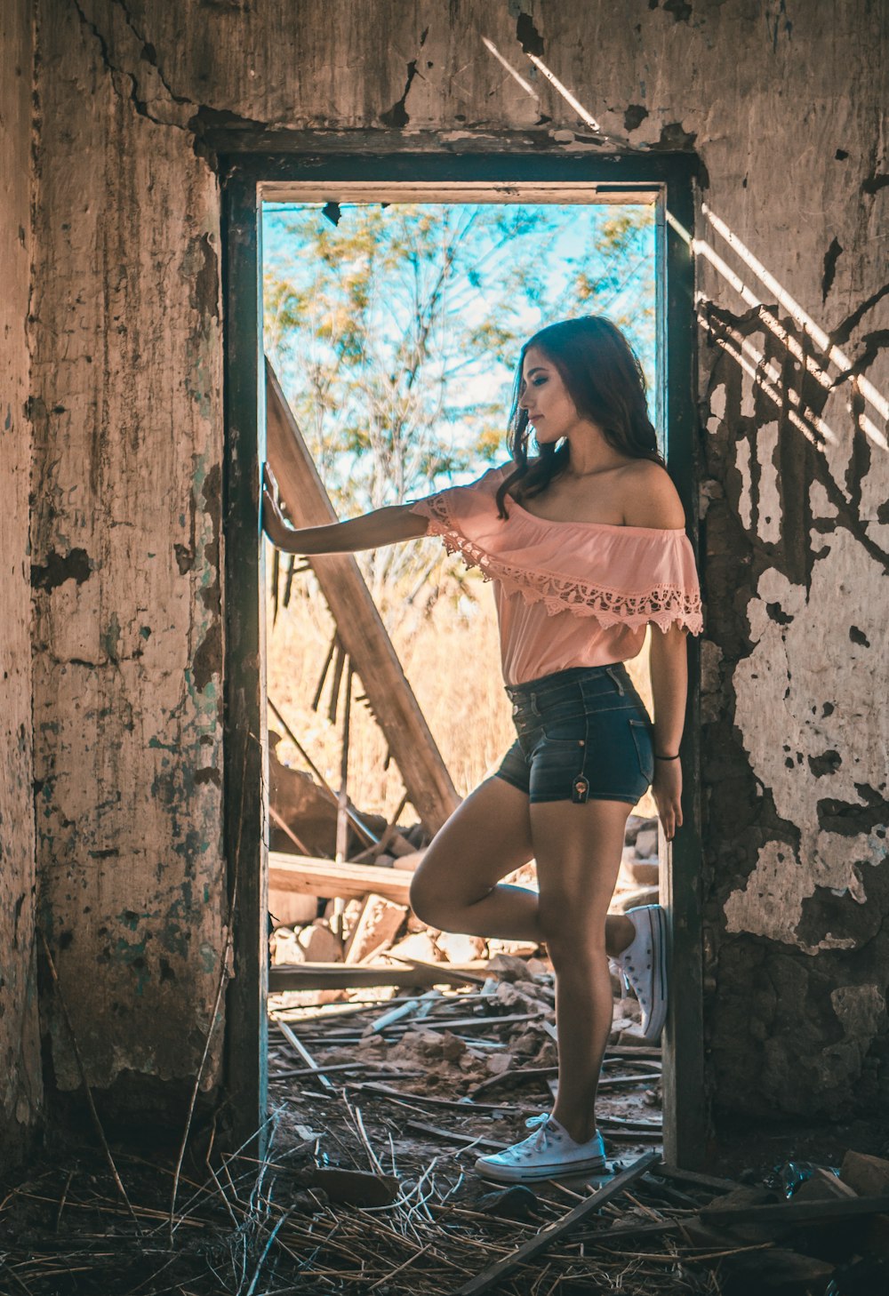 woman in pink off-shoulder top on door