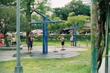 Children playing in a local park with families nearby.
