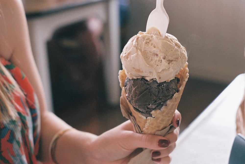 person holding vanilla flavor ice cream