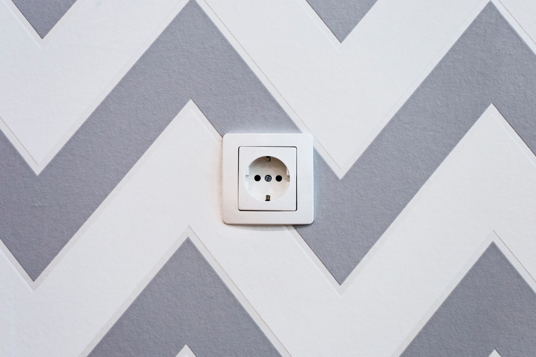 white power strip mounted on white and grey chevron painted wall