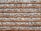 A wall constructed with alternating layers of red bricks and irregularly shaped gray stones, set in light gray mortar, creating a rustic and textured appearance.