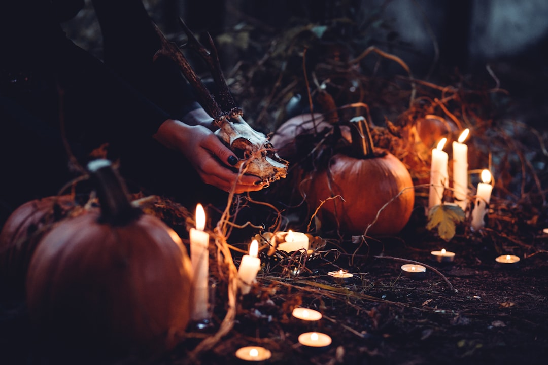 person decorating pumpkin and candles,