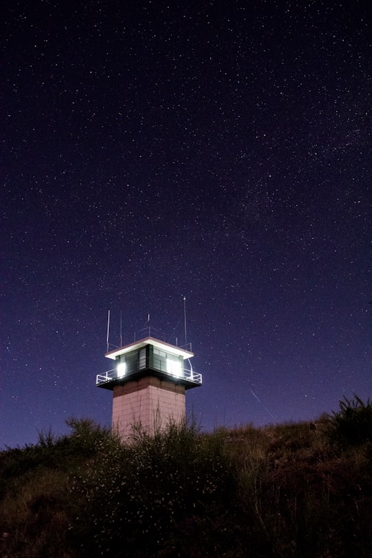 lighted guard house on mountain's peak during night time in Ponteareas Spain