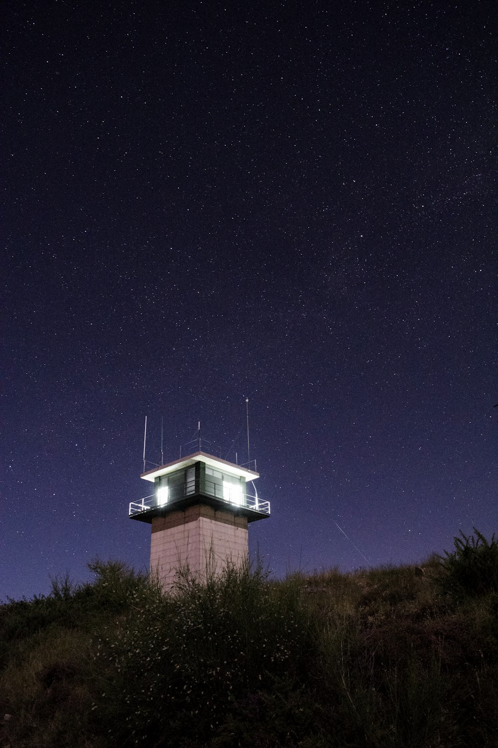 lighted guard house on mountain's peak during night time