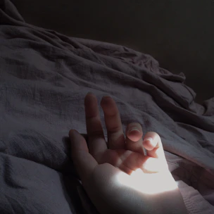 Hands feeling soft cotton fabric with natural light in background