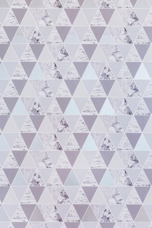 A pattern of geometric shapes composed of triangles. Each triangle is filled with different textures, including marble-like textures, solid colors, and striped designs. The overall arrangement creates a uniform, symmetrical, and aesthetically pleasing surface.