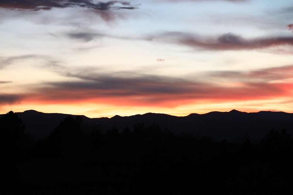 silhouette photography of mountain at sunset