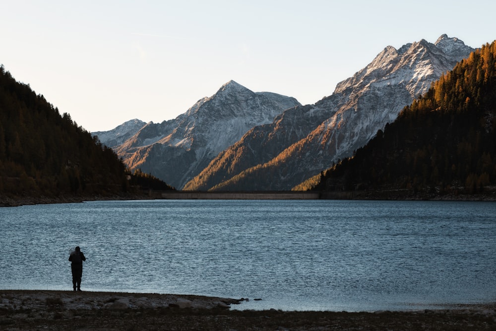 silhouette of person standing near body of water