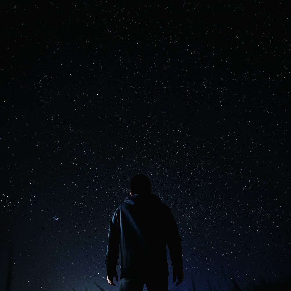 man standing under milky way