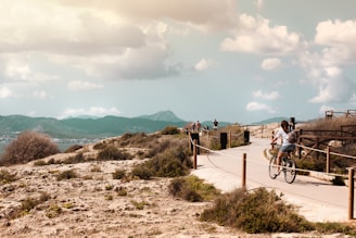 A cyclist riding on a mountain path with scenic views.