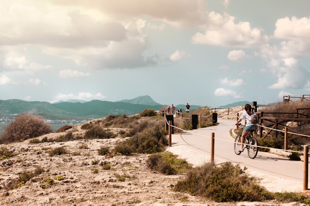 A cyclist riding on a mountain path with scenic views.