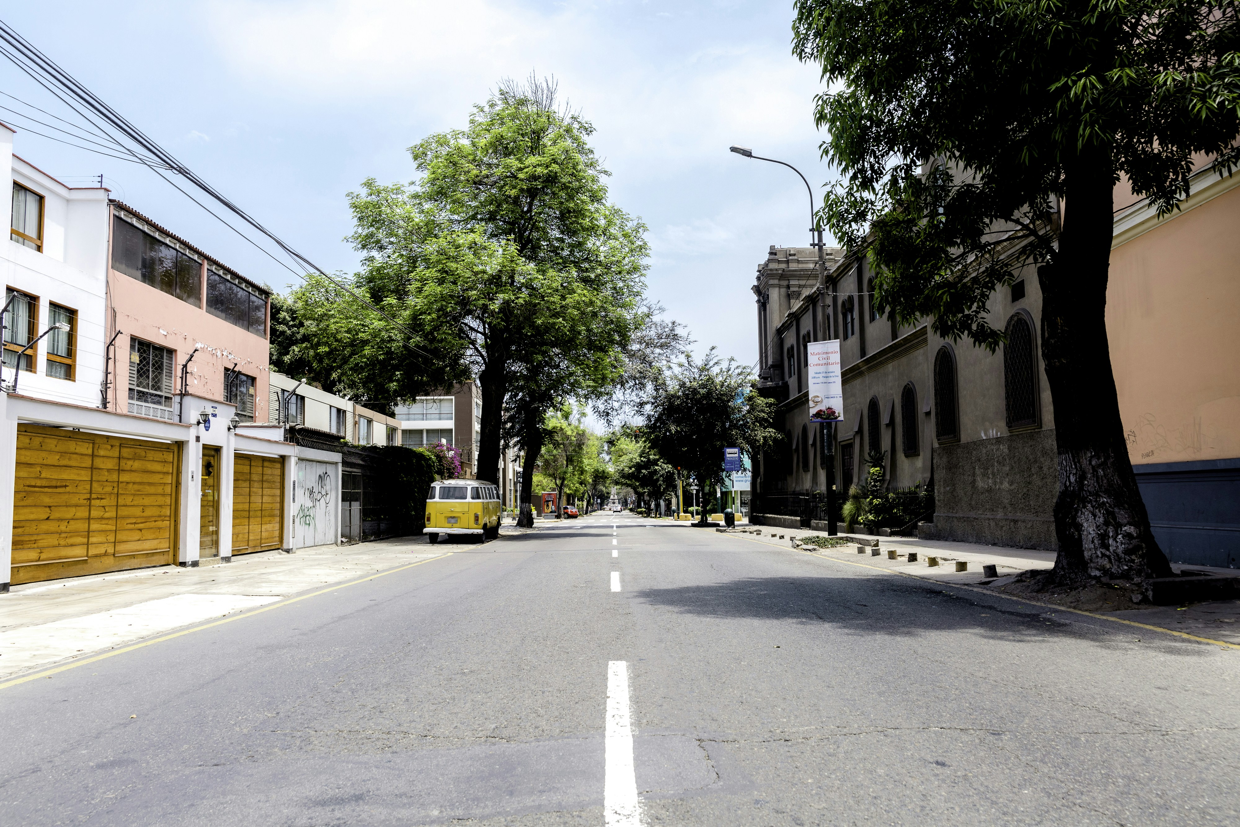 yellow car parked near house, Sunday noon, while all people where participating on the national census, streets look empty and abandoned like it was the first day people left. This is a shot of a hipster neighbourhood Barranco whit -almost- no humans around in the shot.