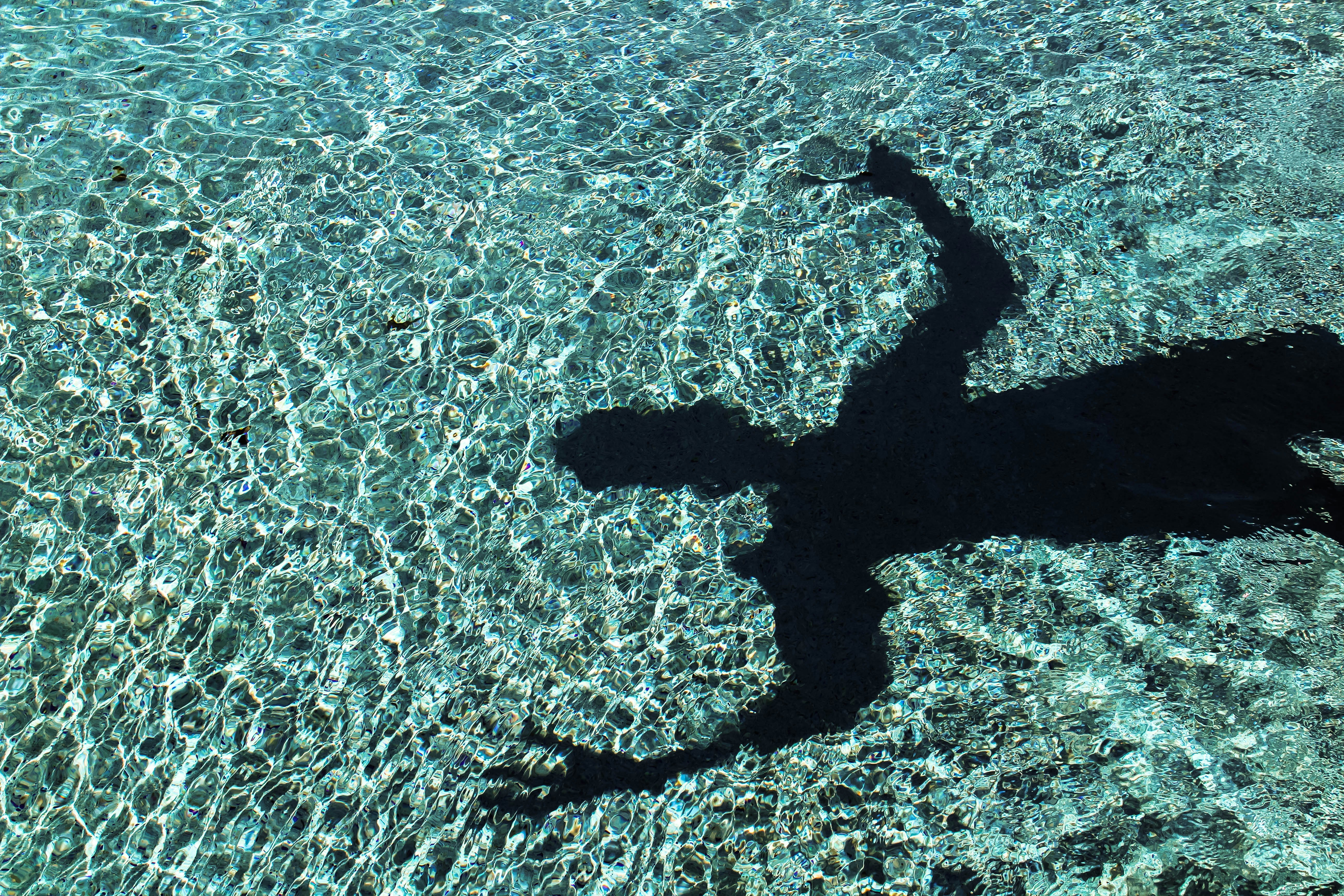 person's shadow reflecting on water