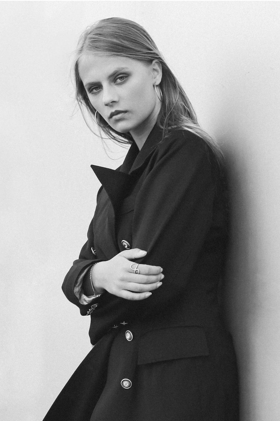 Black and white portrait of a woman leaning on a wall