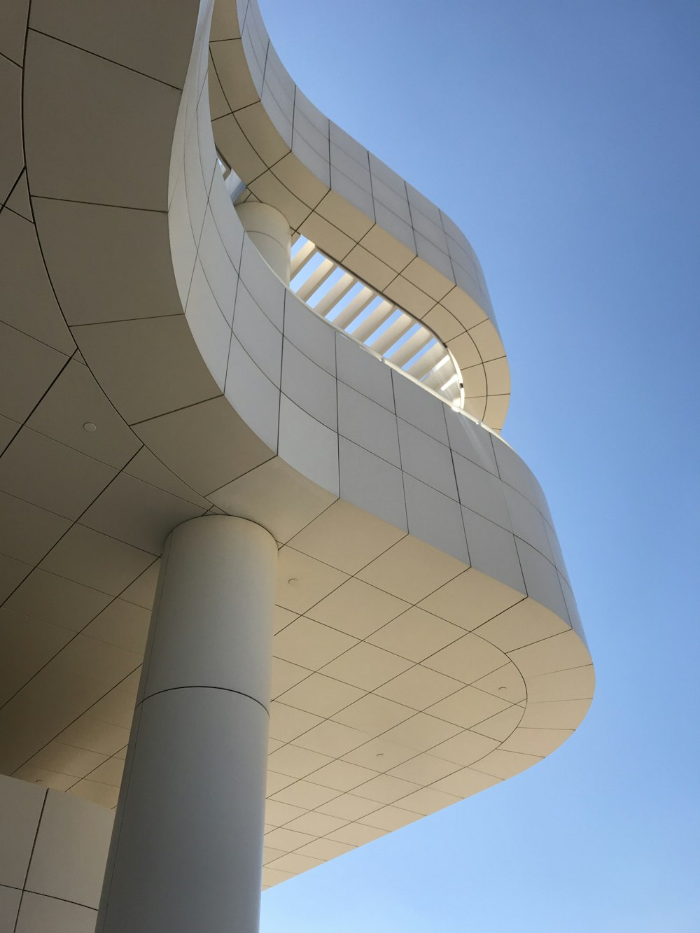 Edificio de hormigón blanco y gris bajo cielo azul