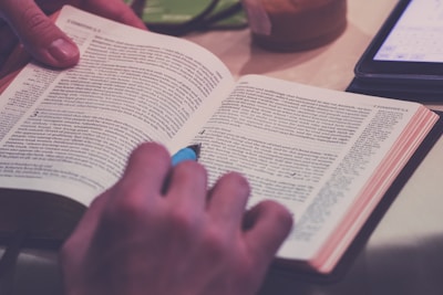 person holding blue pen