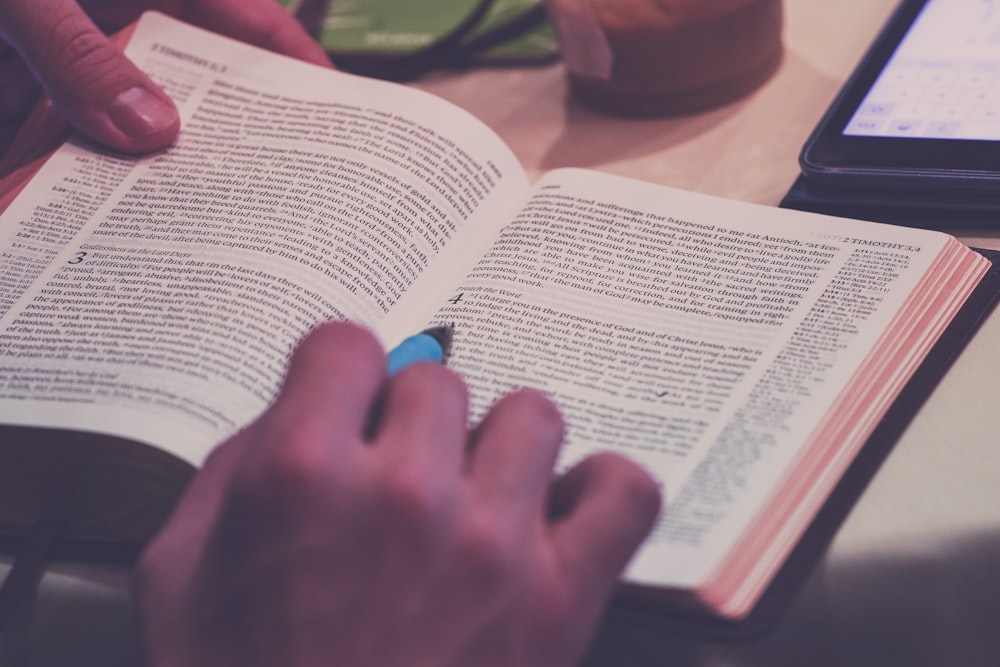 person holding blue pen