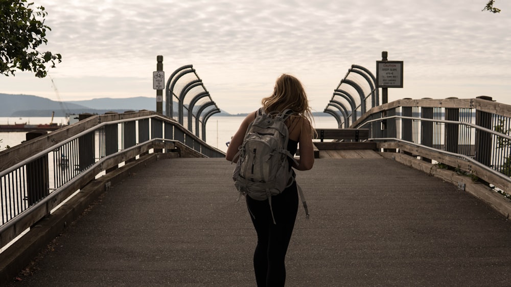 woman in blue denim jacket standing on gray concrete pathway during daytime