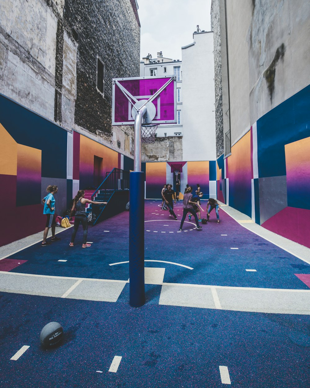 group of men playing basketball on alleyway