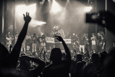 Wide shot of a lively hip hop concert with Moosei Moo engaging the audience.