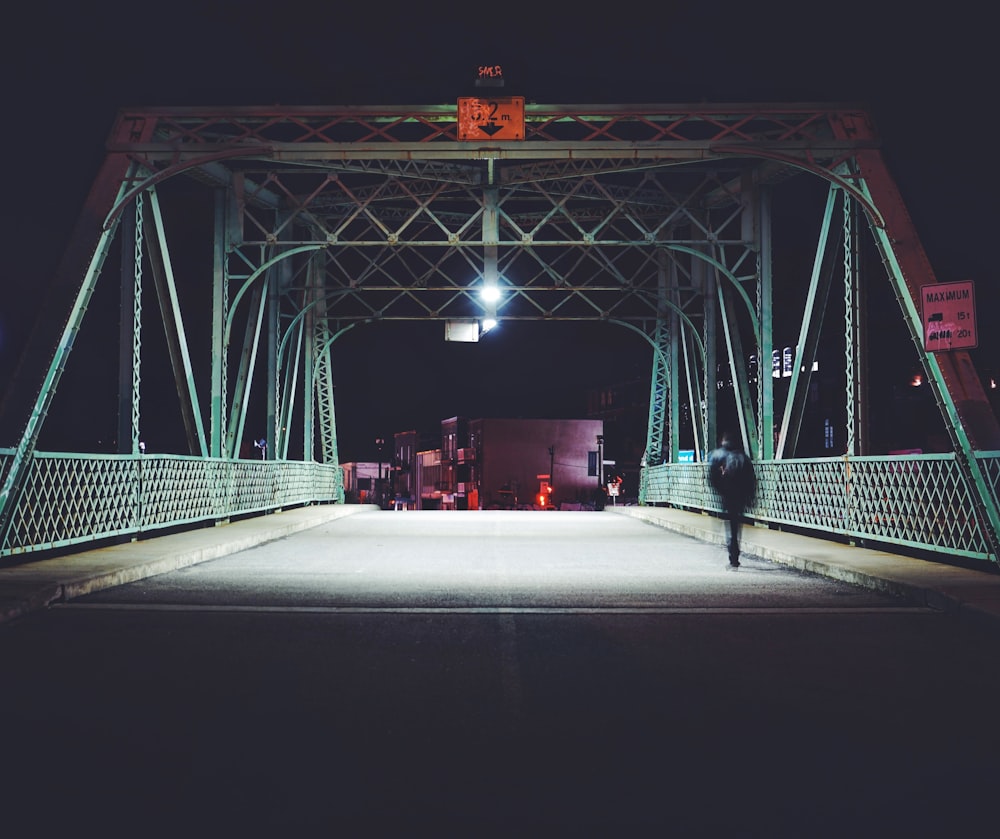 man walking on steel bridge