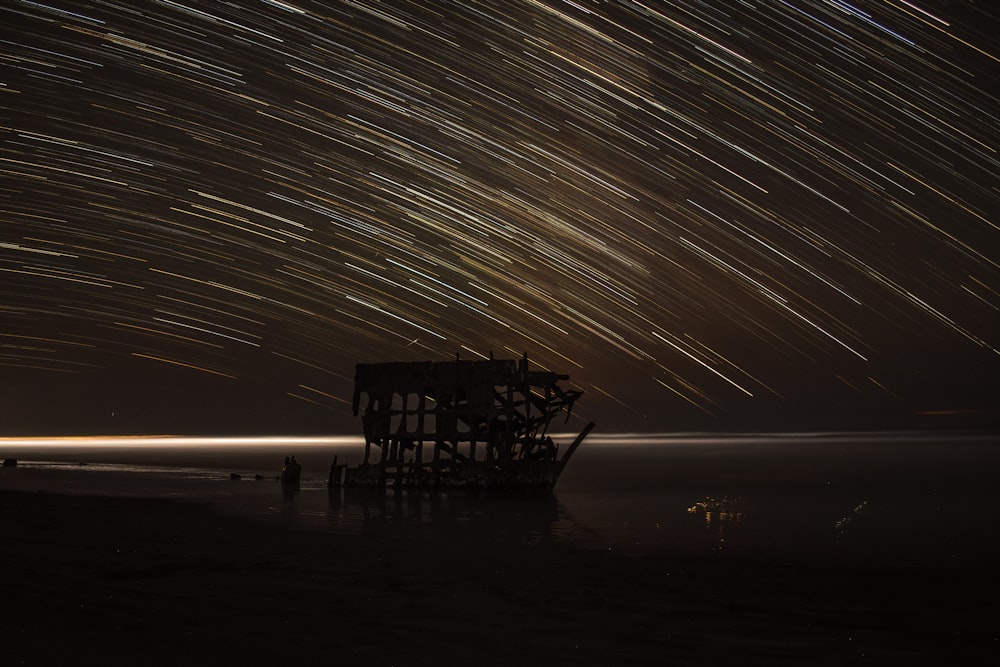 Fotografía de lapso de tiempo de la casa con estrella fugaz en la noche