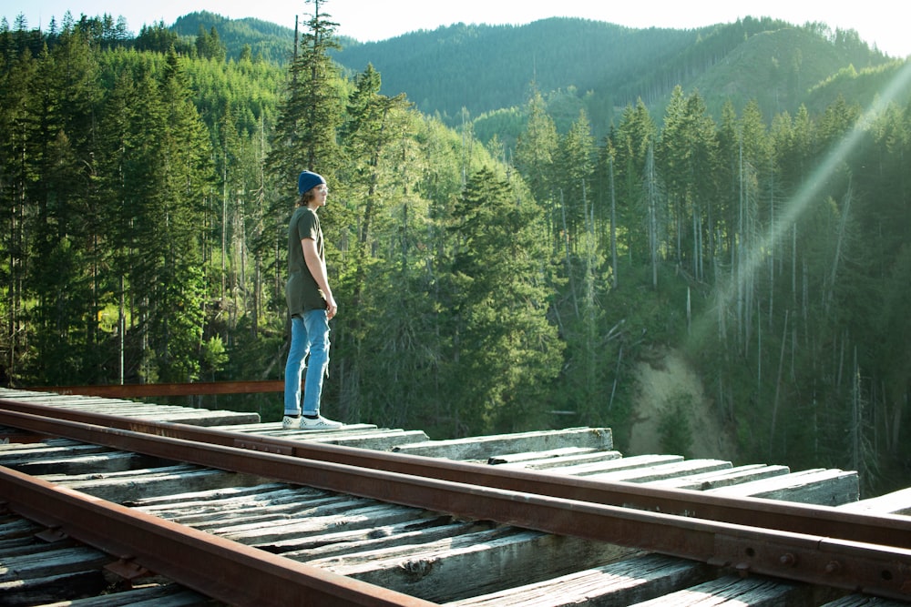 man standing on wooden bridge