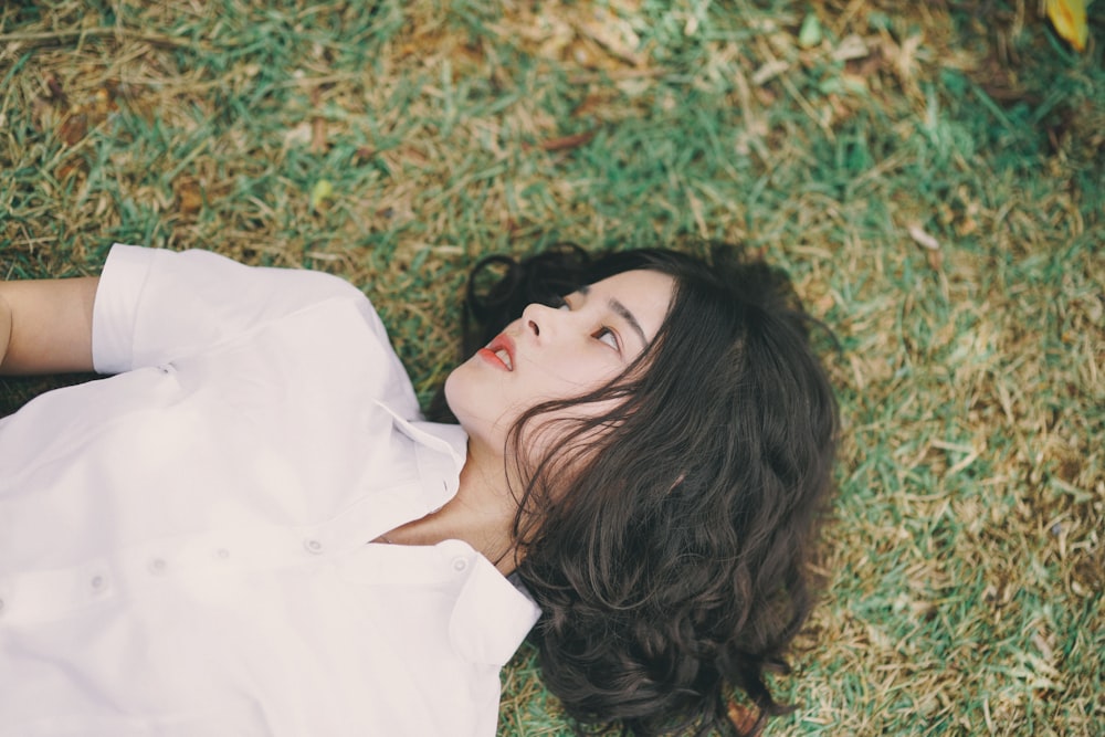 woman lying on green grass