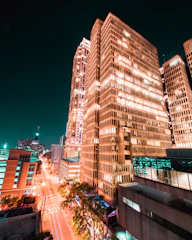 A tall video tile in grayscale showing a dynamic cityscape at night.