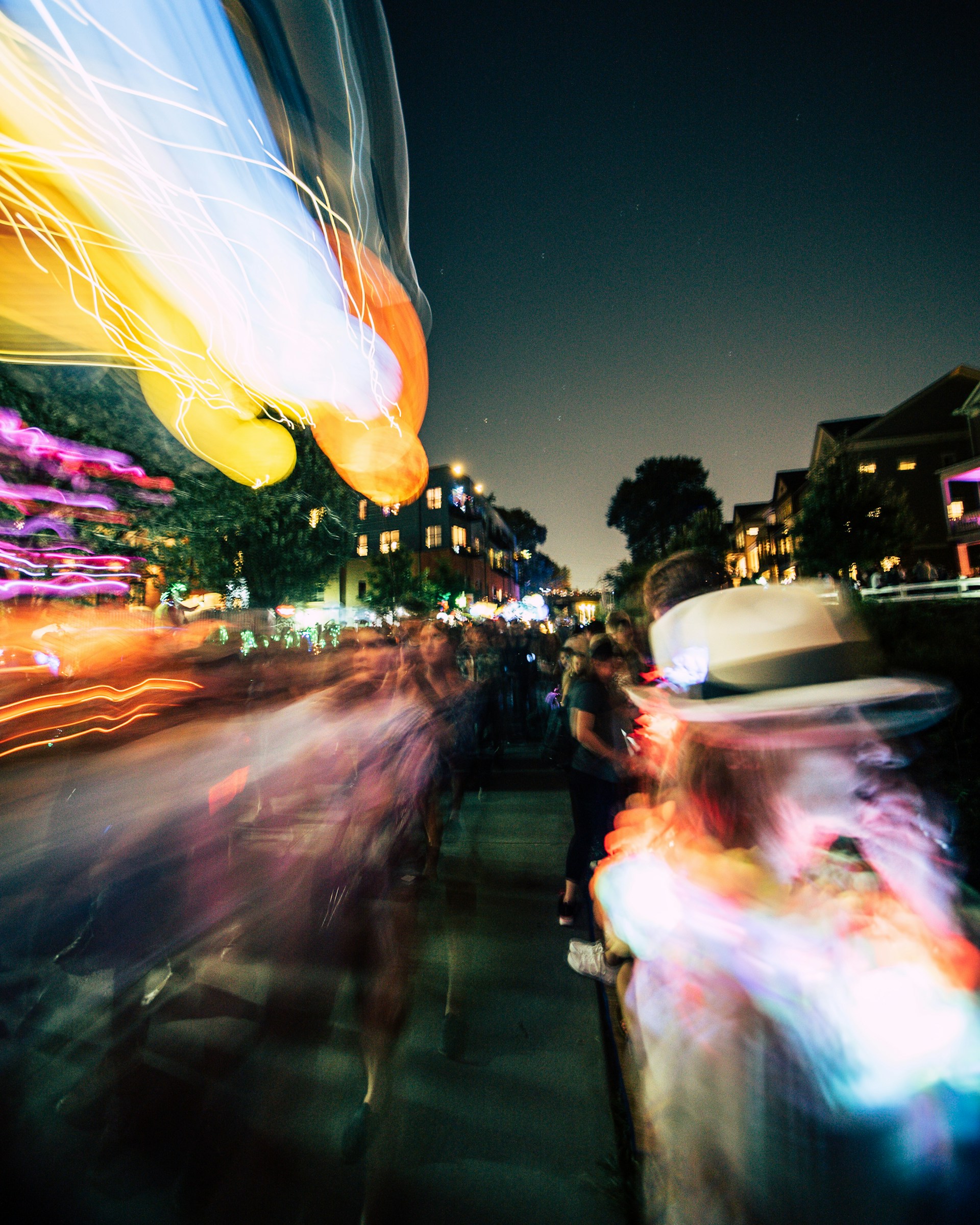 A cinematic frame capturing a lively event scene with expressive faces and atmospheric lighting.