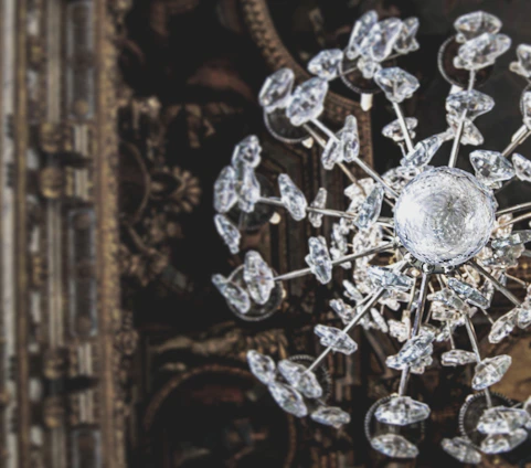 A sparkling neon-lit chandelier glowing with animated glitter effects against a dark backdrop.