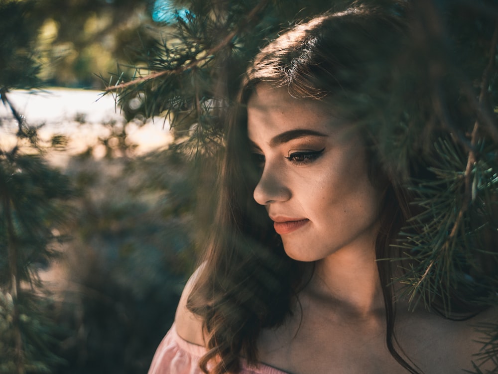 photo of woman standing beside tree