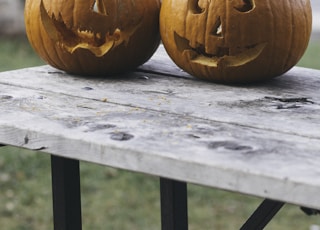 two pumpkins on brown wooden table