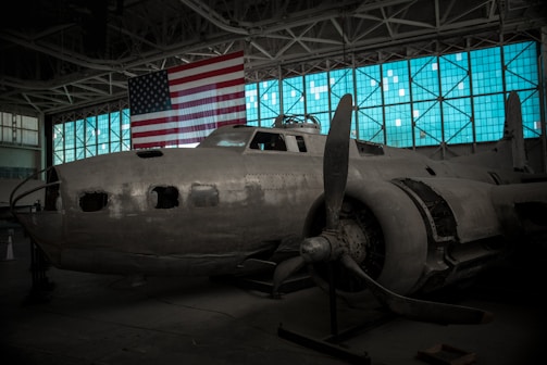 Veteran mentor sharing aviation stories with children inside a hangar.