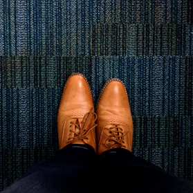 Close-up of elegant leather shoes resting on a natural fiber rug.