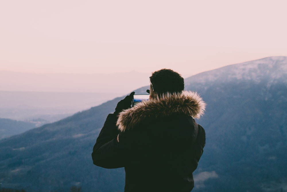 man taking photo on hills