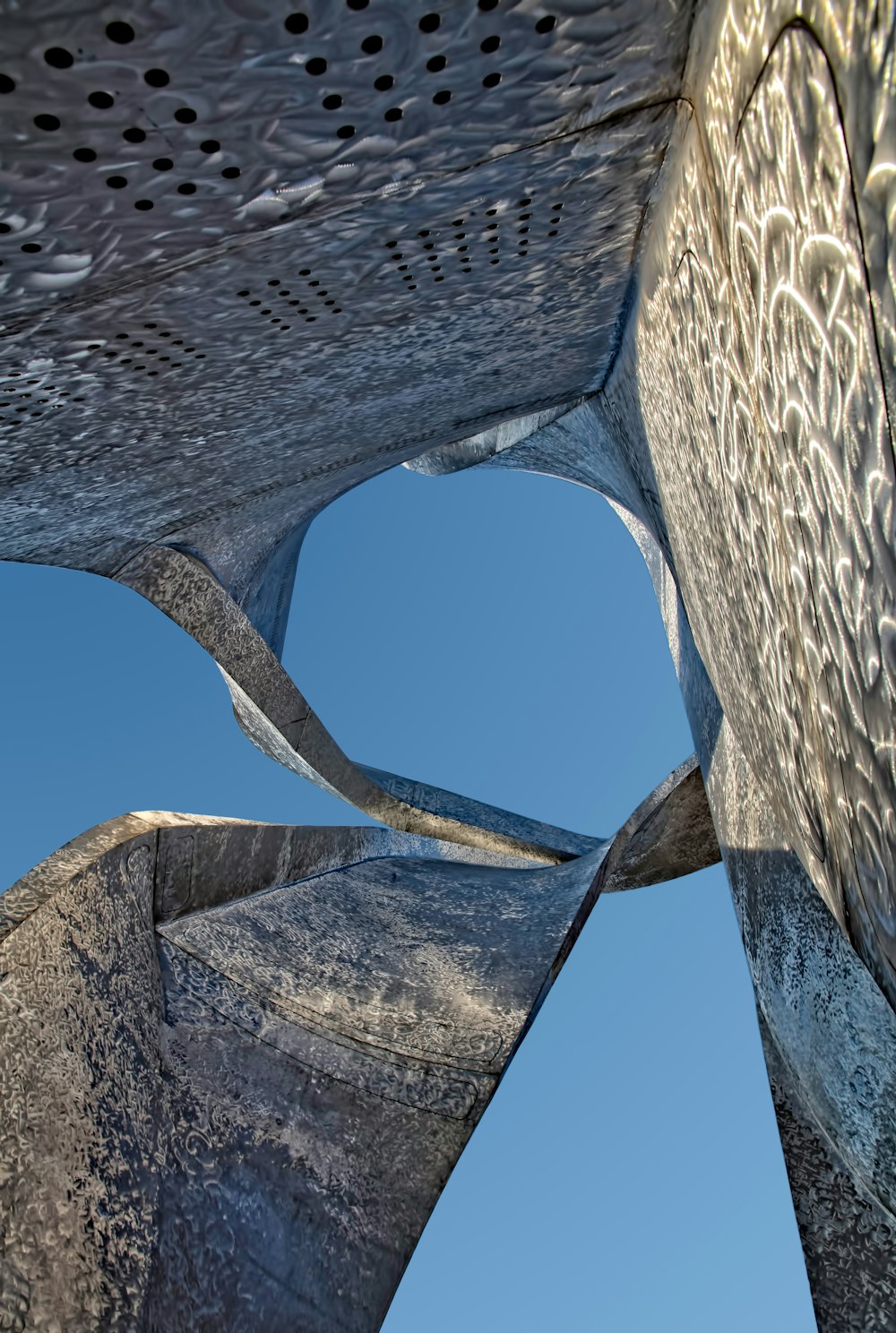 Grauer Betonkunstturm unter strahlend blauem Himmel